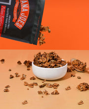 Load image into Gallery viewer, Nana Joes Granola Paleo Sunrise Orange granola pours into a white bowl on an orange background