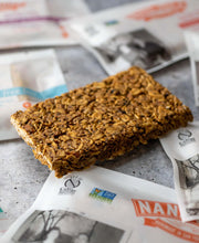 Load image into Gallery viewer, Unwrapped granola bar on a tile counter with other wrapped bars.
