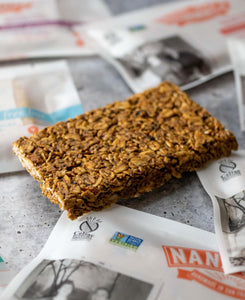 Unwrapped granola bar on a tile counter with other wrapped bars.