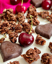 Load image into Gallery viewer, Nana Joe&#39;s granola with cherries and BTR Nation chocolate hearts on a pink cloth
