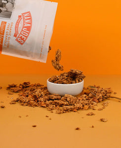 Nana Joes Granola Organic Cluster Peach and Cashew Butter blend pouring into white bowl on orange background