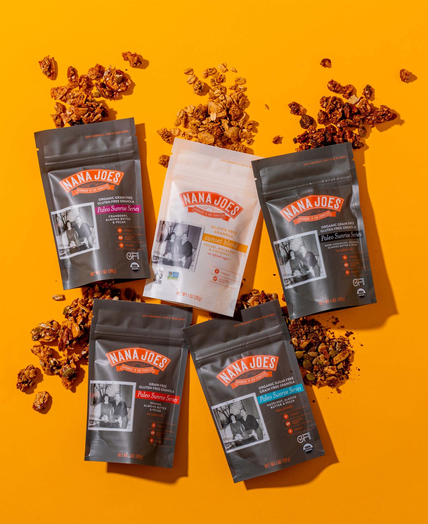 Nana Joes Granola starter pack, bags laid down and spilled on bright orange background